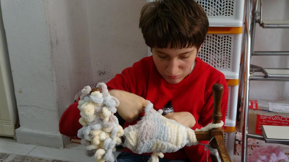 Burdur'da iki parmağını kullanan genç kız, depremzedeler için atkı ördü