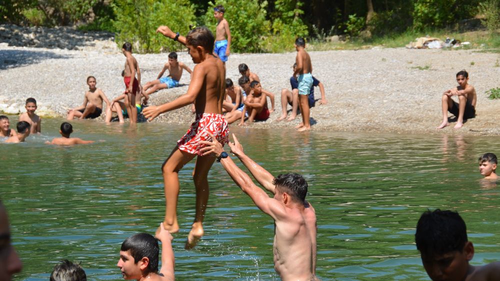 Antalya'ya kampa gelen minik sporcular sıcaktan bunalınca Üzümdere Irmağında biriken gölette serinlediler