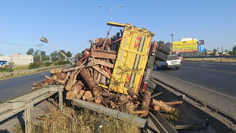 Tomruk yüklü kamyon bariyerleri aşıp refüje devrildi