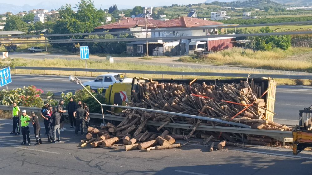 Tomruk yüklü kamyon bariyerleri aşıp refüje devrildi