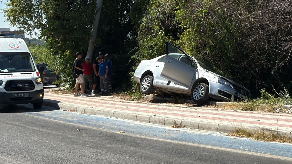Kaldırıma çıkıp asılı kalan otomobildekiler kazayı burnu bile kanamadan atlattı