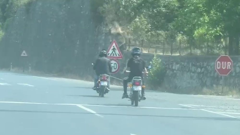 Yolda arızalanan motosiklet, başka bir motosikletliyle halata bağlanarak ilerledi
